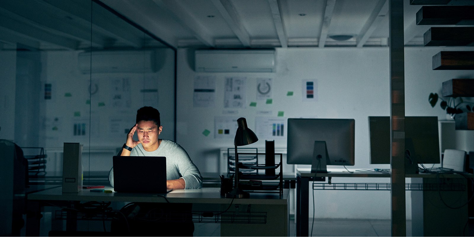 man with hand to head working late alone in the office