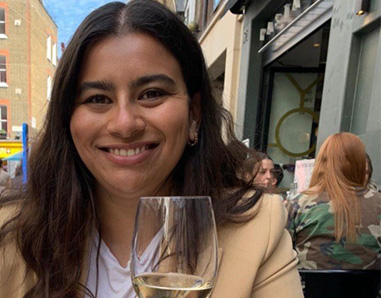 portrait of a woman with dark hair in a tan blazer 