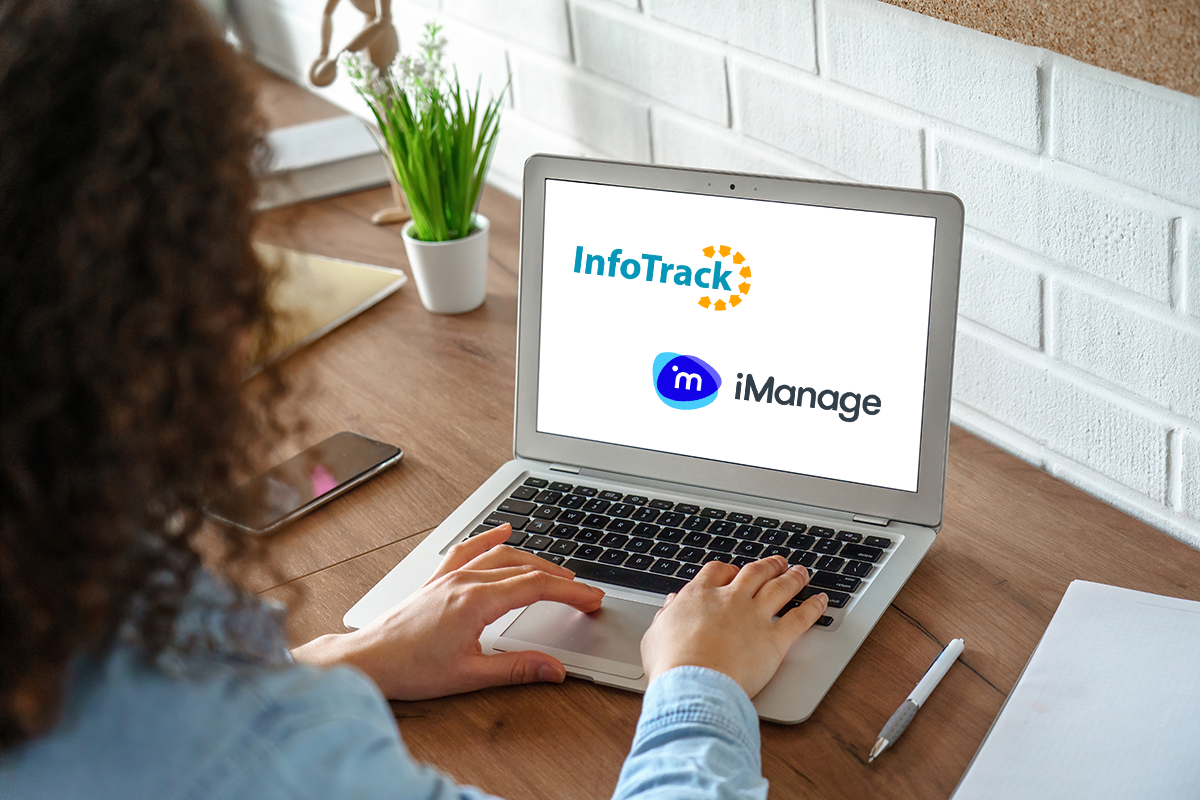 Woman typing on laptop with imanage and InfoTrack logos