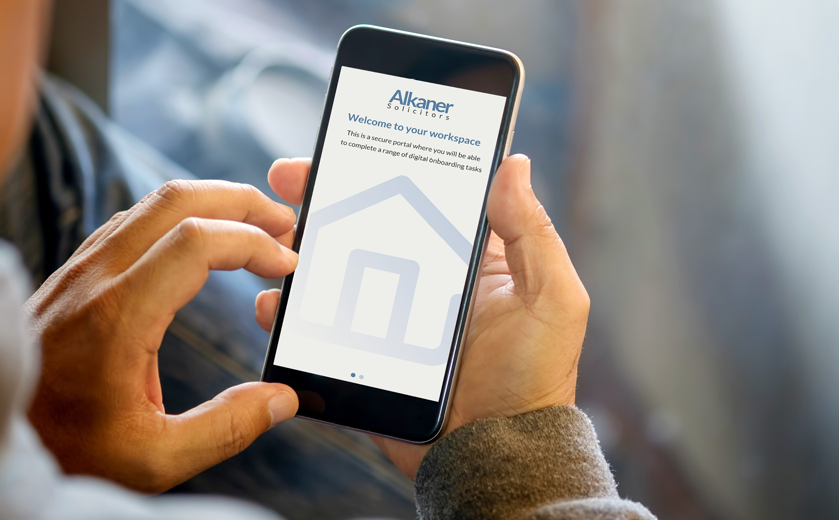 Hands holding mobile phone with Alkaner solicitors welcome screen